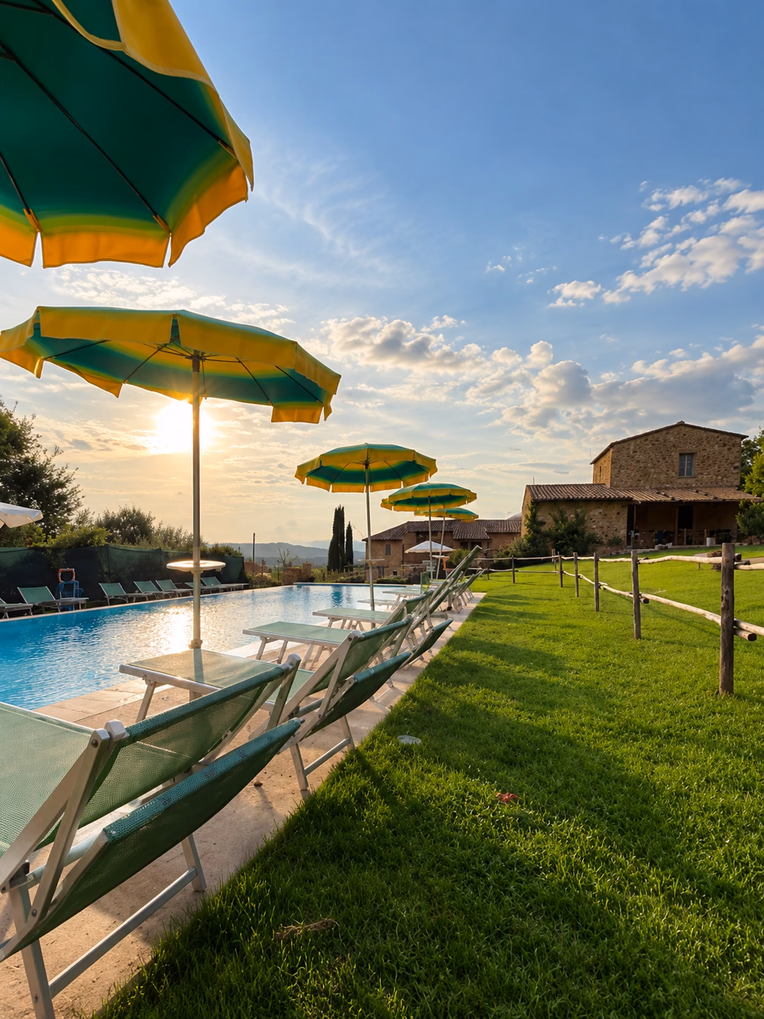 Ombrelloni e piscina al tramonto in Toscana